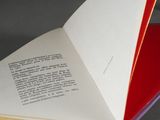 a open book with a red cover on a table