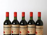 six bottles of wine are lined up on a wooden table