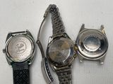 three watches sitting next to each other on a white surface