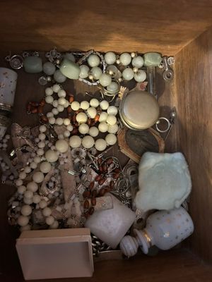 une boîte en bois remplie de nombreux bijoux posée sur une table