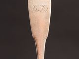 a silver spoon with the word coca on it sitting on top of a table