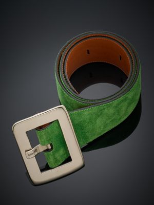 une ceinture verte ornée d'une boucle métallique sur fond noir