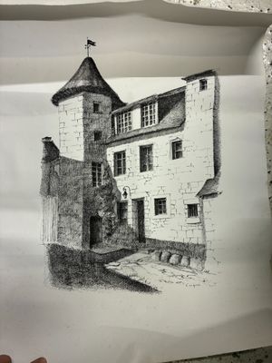 quelqu'un tient un bout de papier sur lequel est dessiné un bâtiment