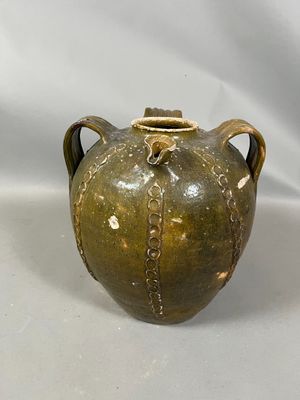 a brown vase that is sitting on a white surface