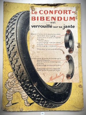 an old poster of a tire on a wall with a picture of a tire