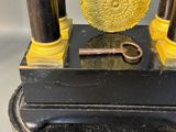 a clock that is sitting on a stand with a key in it