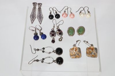 Plusieurs paires de boucles d'oreilles sont exposées dans une vitrine transparente.