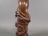 bronze statue of a man holding a bird on a pedestal