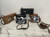 a lot of different types of cameras sitting on a table