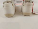 white leather baby shoes with a red box on a white surface