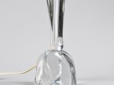 a clear glass table lamp with a metal base and a gold colored cord