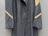une image représentant un manteau accroché au mur à l'aide d'un cintre en bois