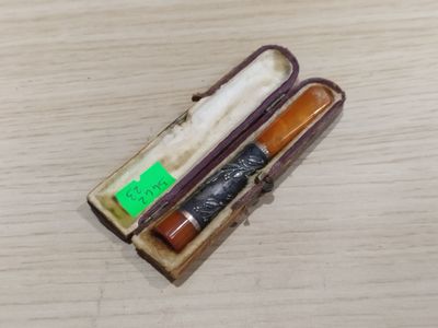 une petite boîte contenant une pipe, posée sur une table
