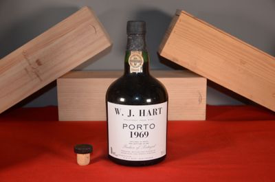 a bottle of wine sitting on a table next to a wooden box