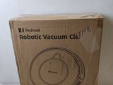 packaging of a robot vacuum cleaner in a cardboard box on a table