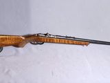 un vieux fusil avec un canon en bois et un étui en cuir