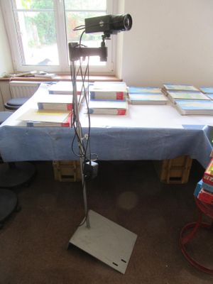 une table sur laquelle sont posés des livres et un appareil photo, dans une pièce