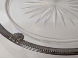 a glass plate with a metal handle on a table