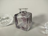 a small glass bottle and a small glass bowl on a table