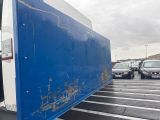 a blue and white bus that is sitting in a parking lot