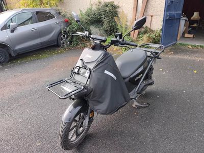 une moto garée dans la rue devant une voiture