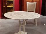 une table et des chaises blanches dans une pièce aux murs rouges
