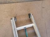 a ladder leaning up against a wall with a hose attached to it