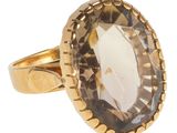 un gros plan d'une bague en or sertie d'une grosse pierre facettée