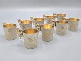 six silver cups with butterflies on them are lined up in a row