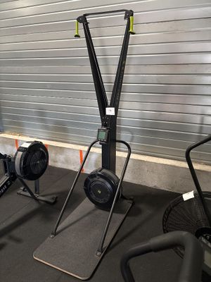 une salle de sport équipée d'une rangée d'appareils de musculation fixes