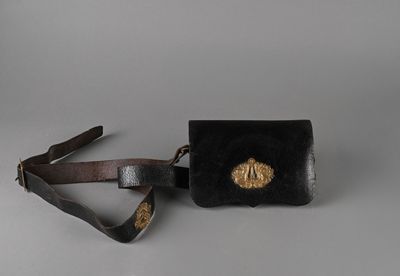 un sac à main noir avec une boucle dorée et une bandoulière marron