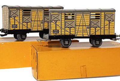 deux wagons de train miniature posés sur une boîte jaune