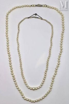 a white pearl necklace with a gold clasp and two strands of pearls