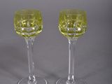 pair of yellow glass wine glasses on a grey background