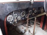 dashboard of an old car with many gauges and a steering wheel
