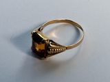 an image of a gold ring with a brown stone on it
