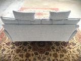 an image of a living room with a couch and a rug