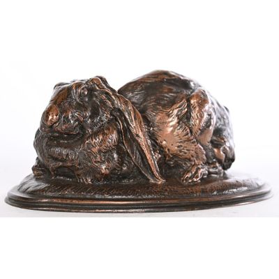 statue représentant deux chiens couchés sur une assiette, sur fond blanc