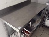 a stainless steel work table in a kitchen with pots and pans on it