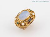 a close up of a ring with a blue stone surrounded by multi colored stones