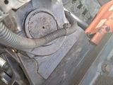 a close up of a car ' s engine with a hose attached to it