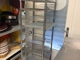 une étagère en métal sur laquelle sont posés tout un tas de plats