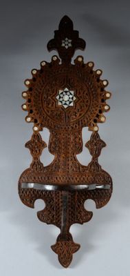 a wooden wall clock hanging on a white wall