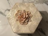 a white box with a flower on it on a marble table