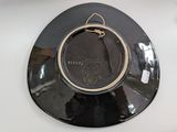 a black plate with a gold rim on a white table