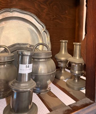 a lot of silver vases and plates on a shelf