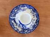 a blue and white cup and saucer on a wooden table
