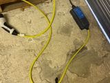 un cordon jaune relié à un appareil noir et blanc