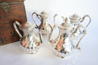 trois théières en argent posées sur une table à côté d'une boîte en bois