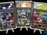 Quatre cartes Pokémon différentes sont exposées dans une vitrine.